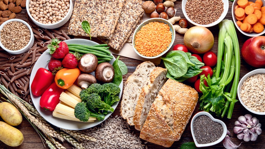 Table of foods including whole grain bread, chia seeds, and vegetables that are high in dietary fiber